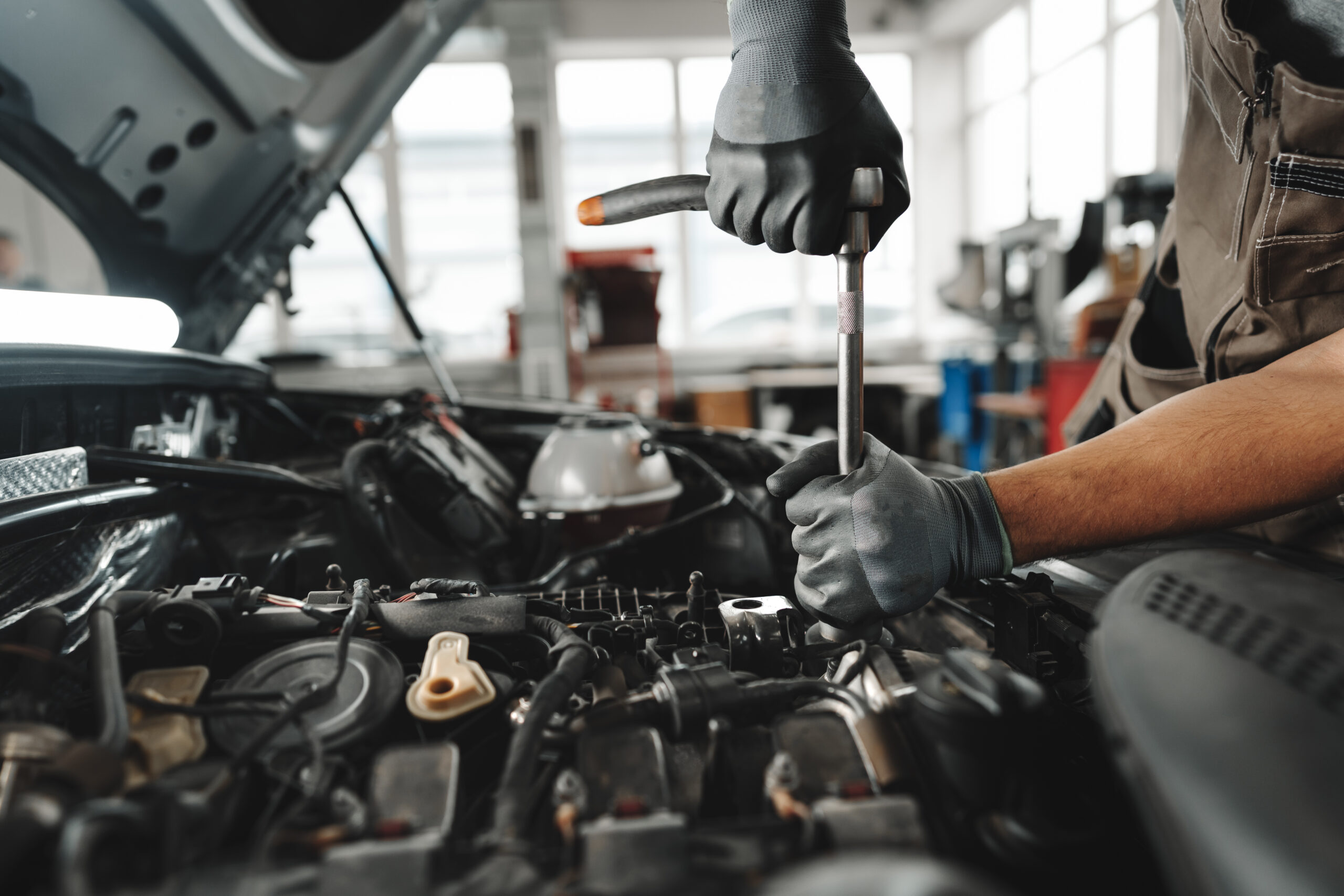 Mechanic working under the hood in Red Deer auto shop performing engine repair and maintenance services